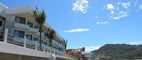 Un hotel frente al mar con diseño moderno, con balcones y vistas al océano.