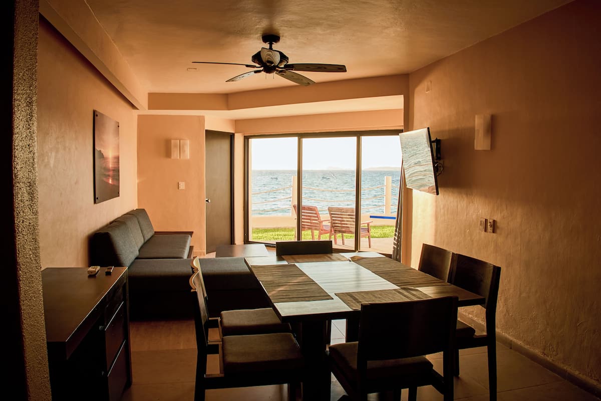 Un comedor con una mesa grande, sillas, un sofá y un ventilador de techo.