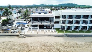 Un resort con piscina, sillas de descanso y zona de playa.