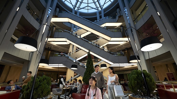 A multi-level atrium with escalators, seating areas, and potted plants. - Resorts World Genting RW Hotel (Genting Highlands)