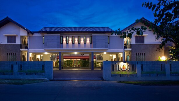 A hotel entrance with a modern design, featuring a central entrance flanked by two wings. - Hotel Ilos (Bandung)