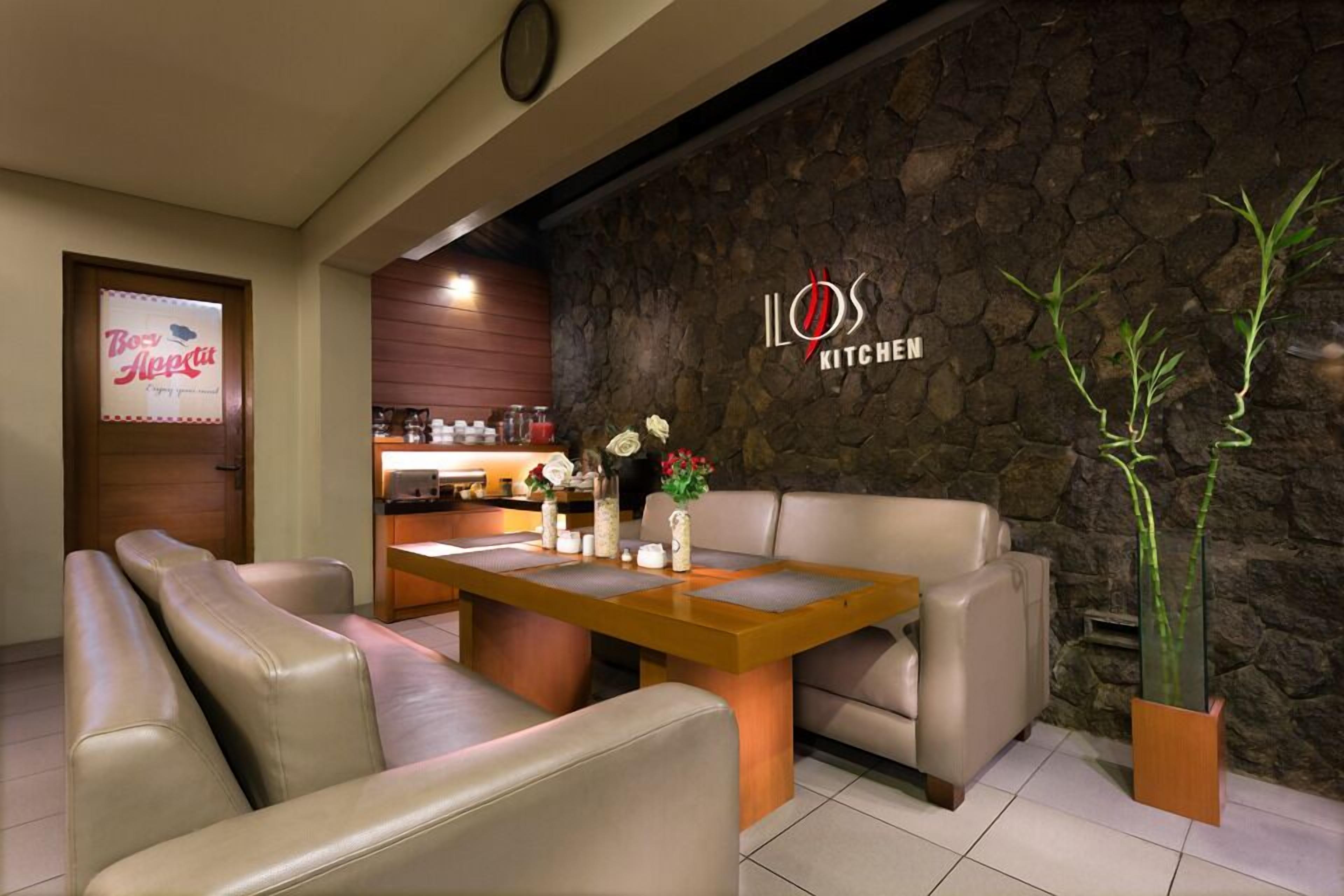A modern kitchen area with a stone wall and a wooden table.