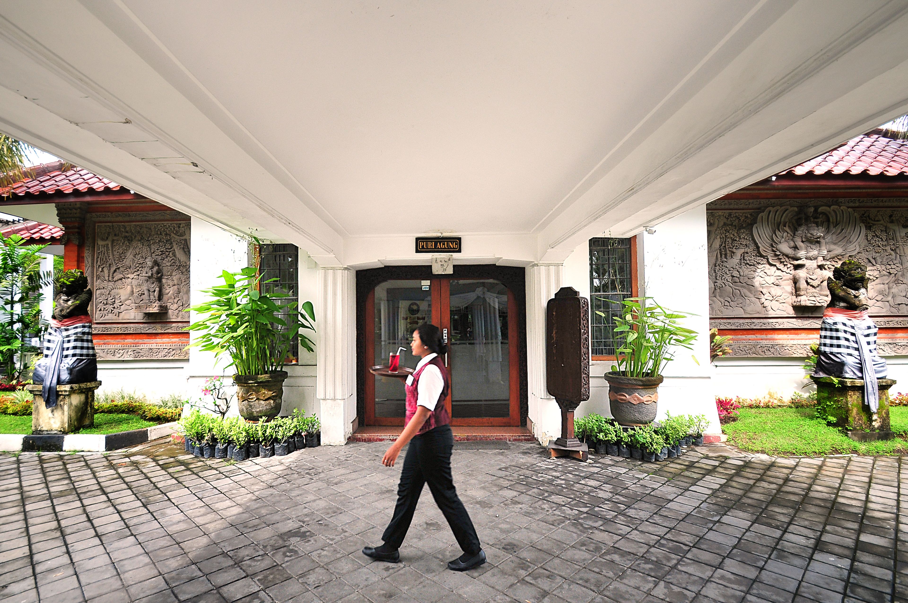Entrada de un hotel con un letrero que dice "PUB AUNG" y una persona caminando al frente.