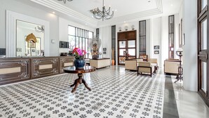 A spacious lobby with a patterned floor, a reception desk, and a chandelier. - Inna Bali Heritage Hotel (Denpasar)
