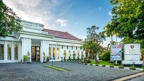 A white building with a red roof, potted plants, and a sign for Inna Bali Hotel. - Inna Bali Heritage Hotel (Denpasar)