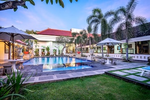 Una piscina al aire libre, sombrillas, sillones reclinables de piscina
