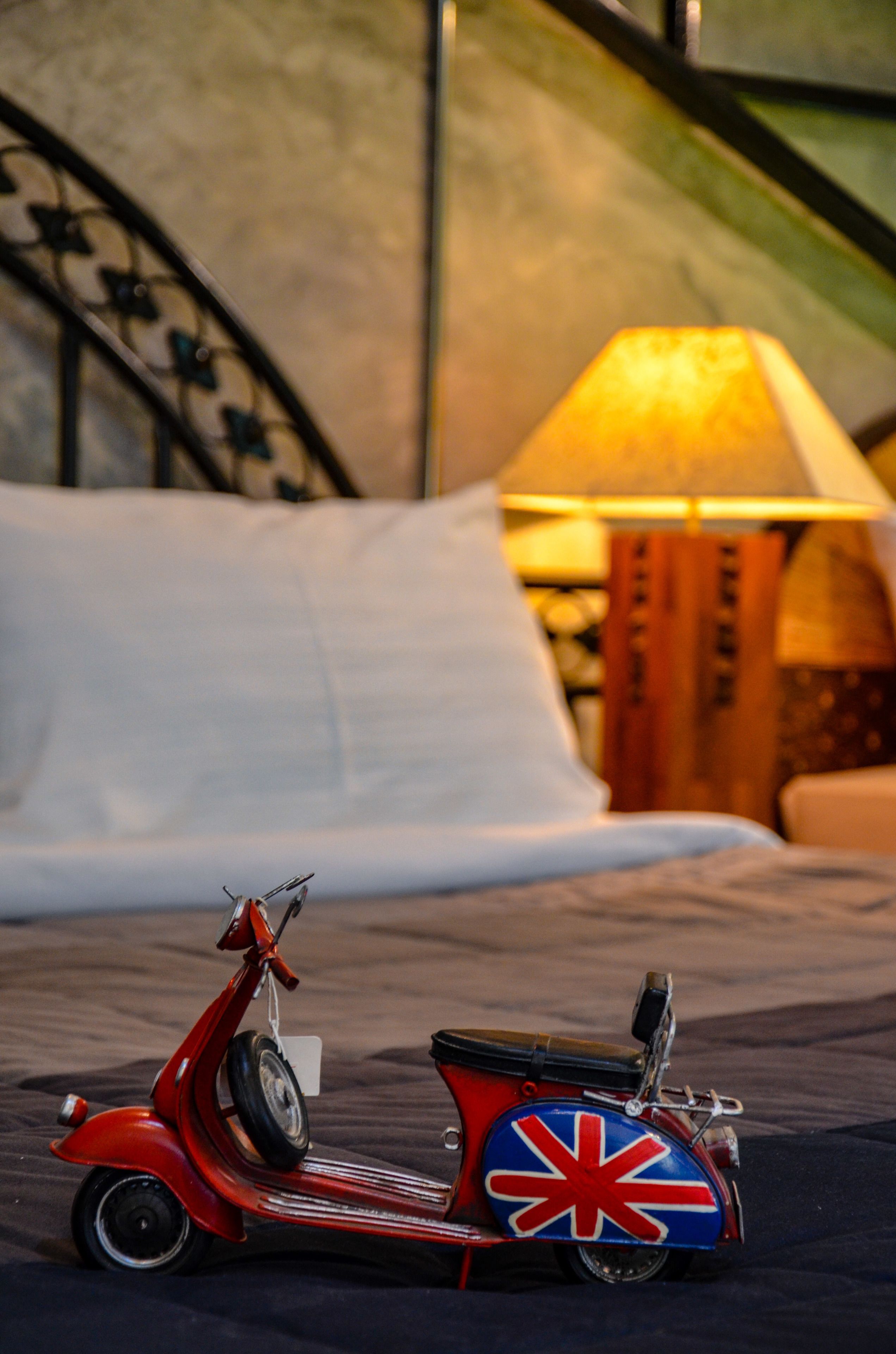 A red scooter with a Union Jack design on a bed.