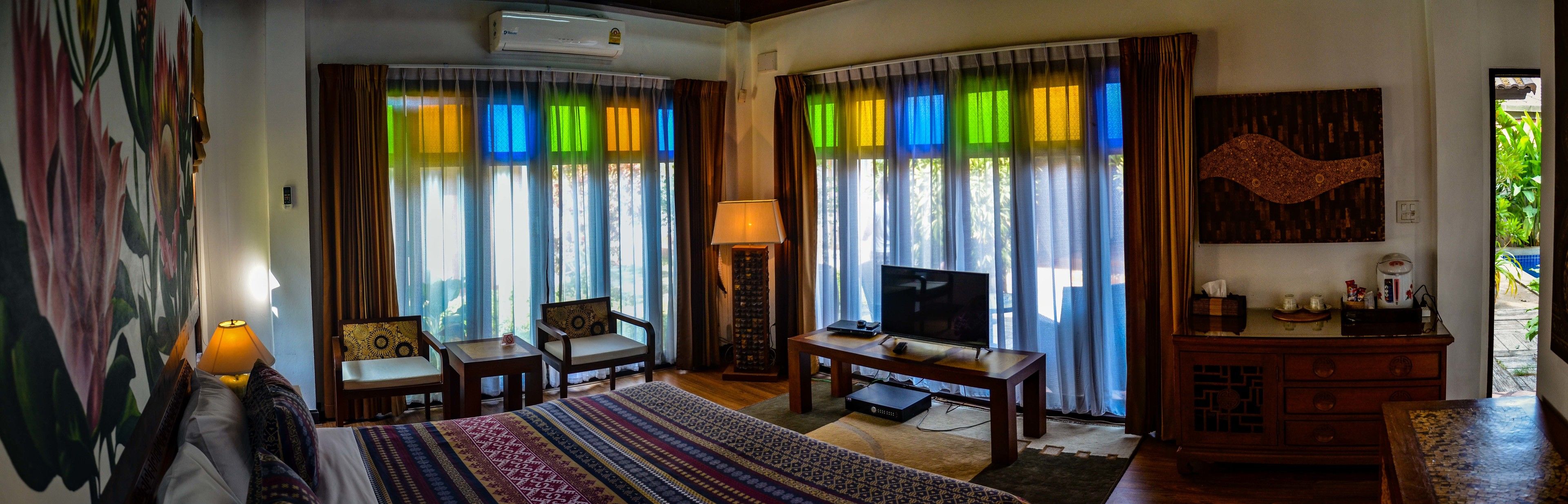 Une chambre d’hôtel avec un lit, un bureau, une télévision et une chaise.