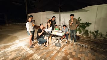 Gather with friends and family in a lively outdoor setting, complete with a table for sharing and a beautiful palm plant.