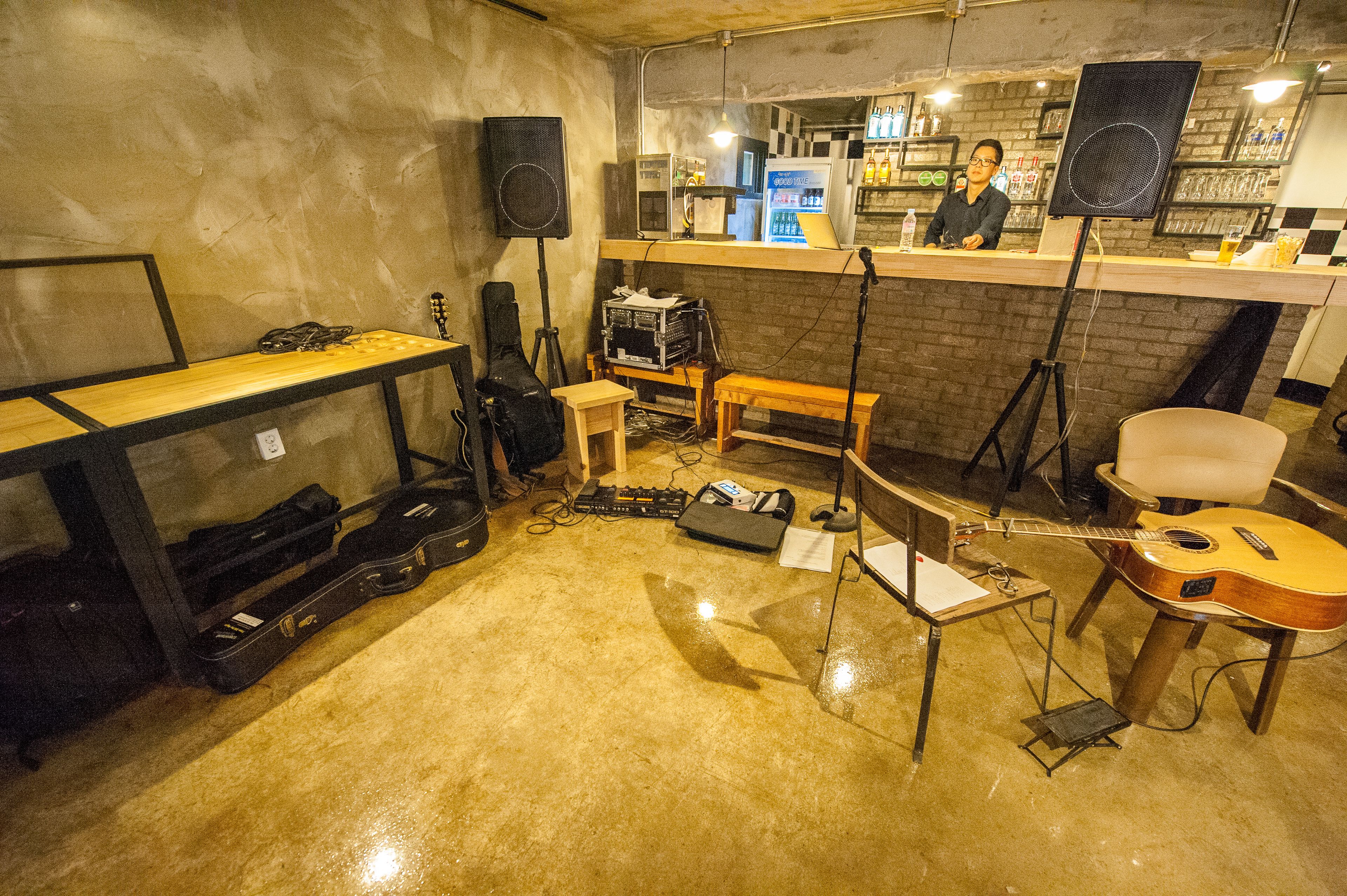 Un estudio de música con instrumentos, una mesa de mezcla y una zona de bar.