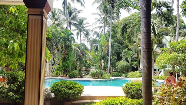 A pool surrounded by lush greenery and palm trees, with a clear view of the pool area. - Rattana Guesthouse & Bungalow (Koh Samui)