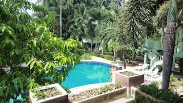 Alberca al aire libre y camastros