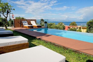 Alberca al aire libre y camastros 