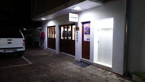 A building with a reception area, a parking lot, and a white van parked outside. - Sleepers Villa (Polokwane)