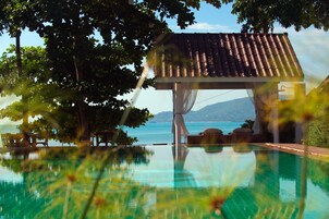 Una piscina al aire libre, sillones reclinables de piscina