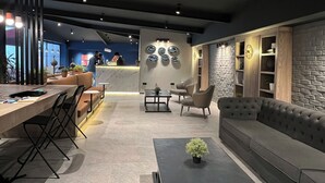 Ein modernes Interieur mit einer Rezeption, einer Sitzecke und dekorativen Wandelementen.