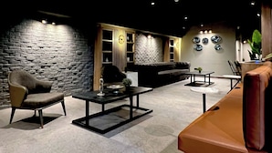 Ein modernes Interieur mit einer Steinwand, einem Sofa, einem Couchtisch und einem Ledersofa.