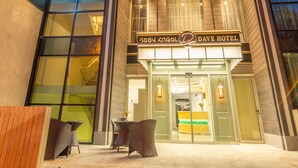 A modern hotel entrance with a glass facade, outdoor seating, and a sign for 'Dave Hotel'. - Dave Hotel Yerevan (Yerevan)