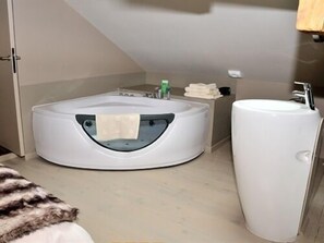 Un baño moderno con una bañera independiente, un lavabo y un perchero para toallas.