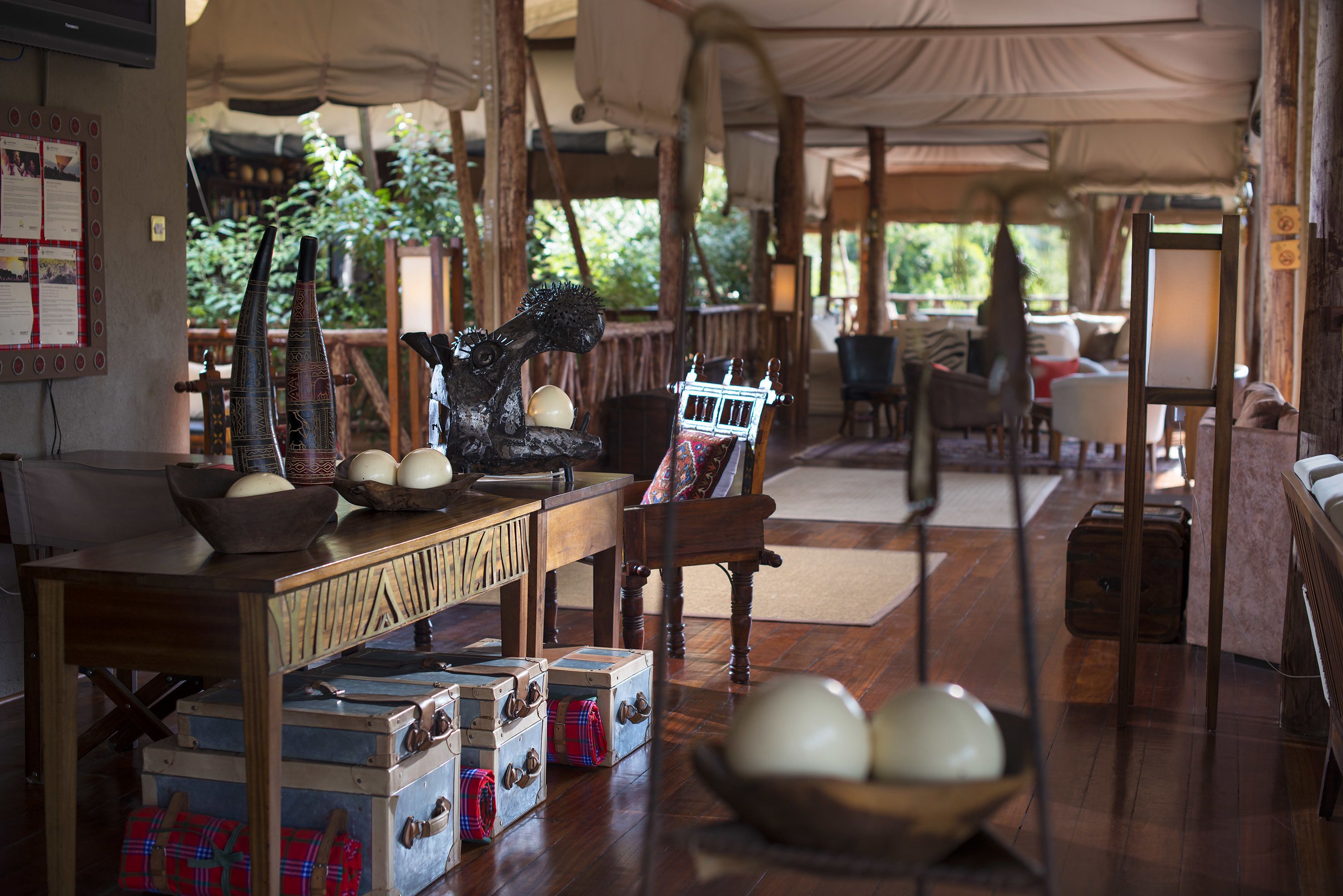 A rustic interior with wooden furniture, vintage trunks, and a decorative horse statue.
