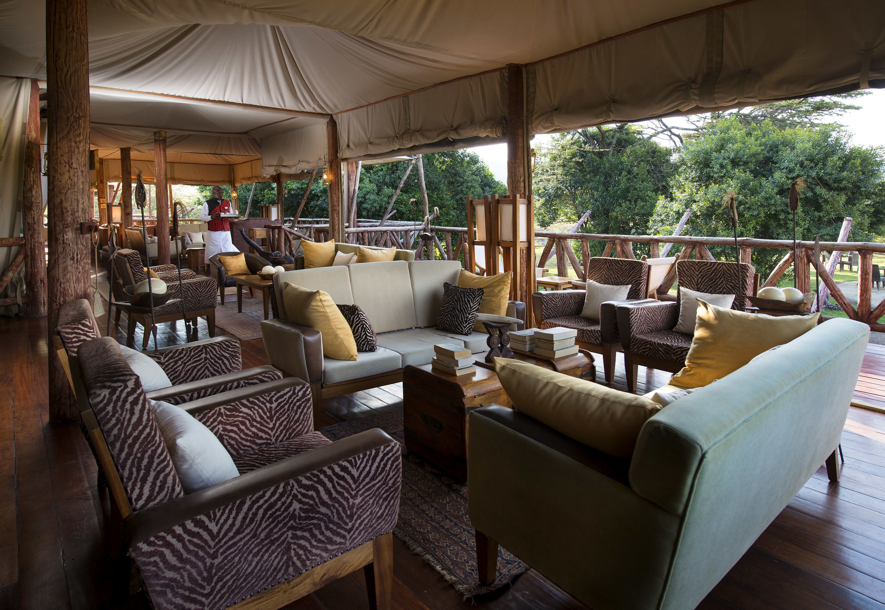 A tented lounge area with multiple seating options, including sofas and chairs, arranged around a central coffee table.