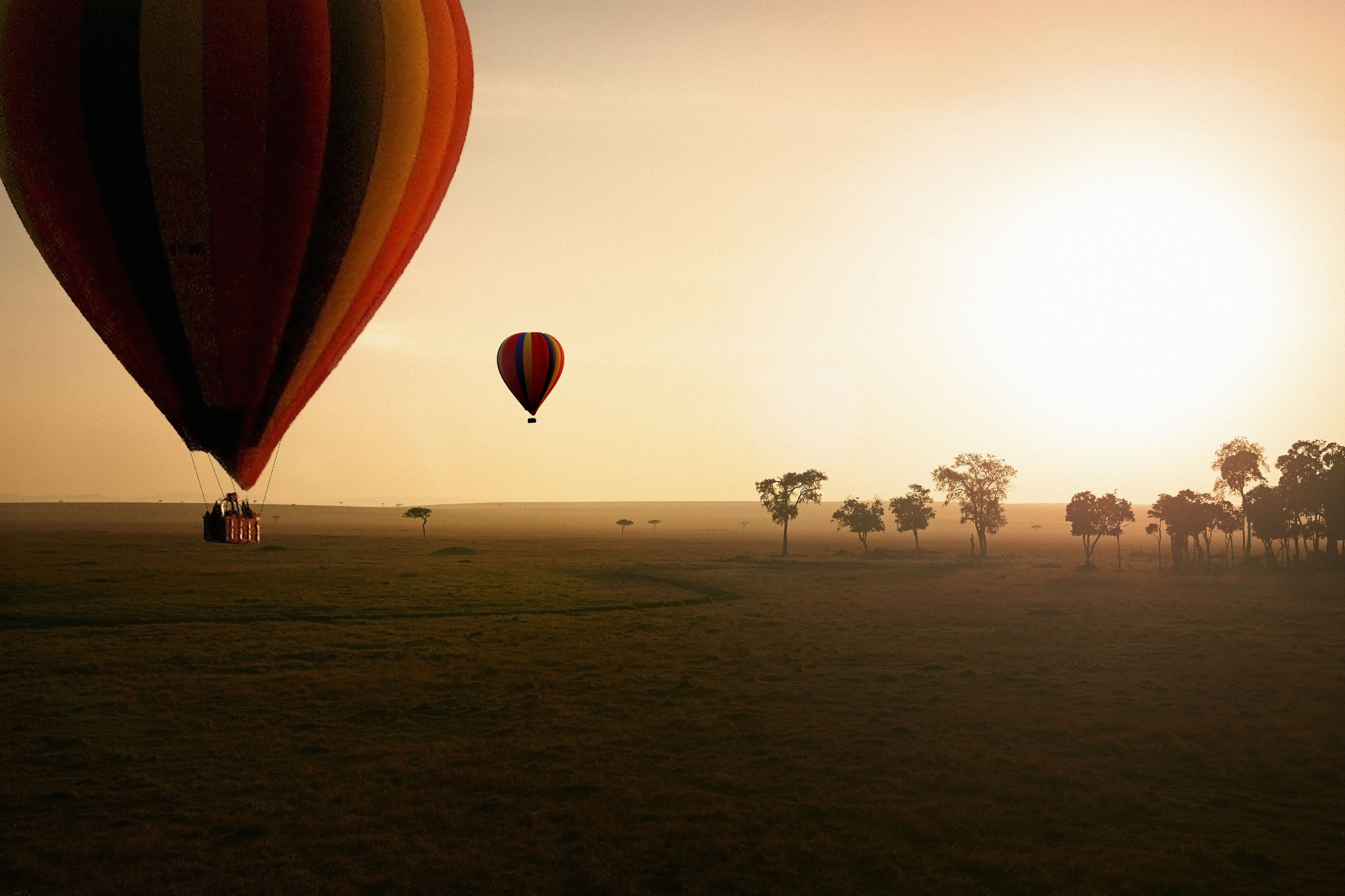 Un ballon à air chaud sur un vaste champ dégagé, sous un ciel clair.