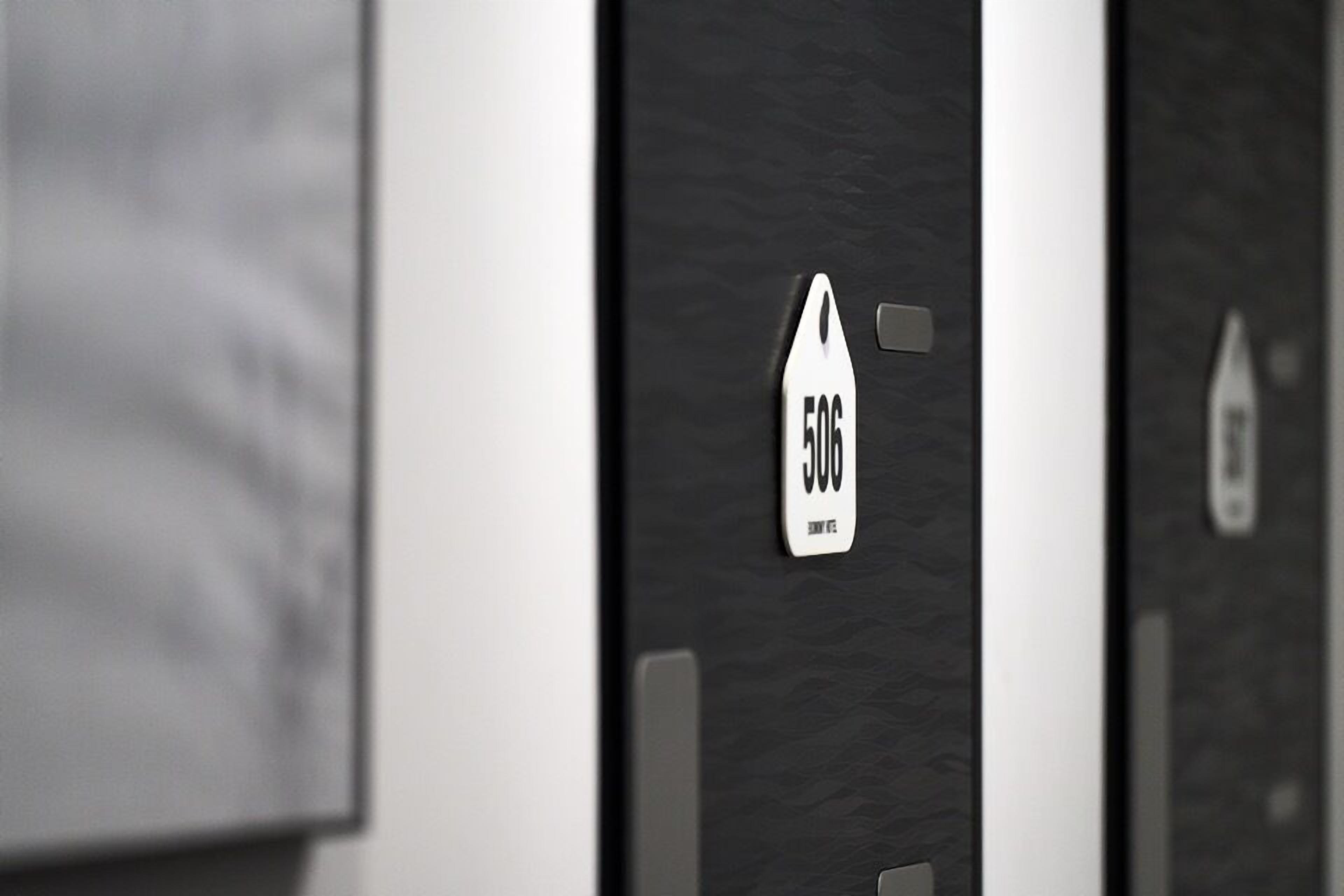 A hotel room with a door labeled '506' and a small window.