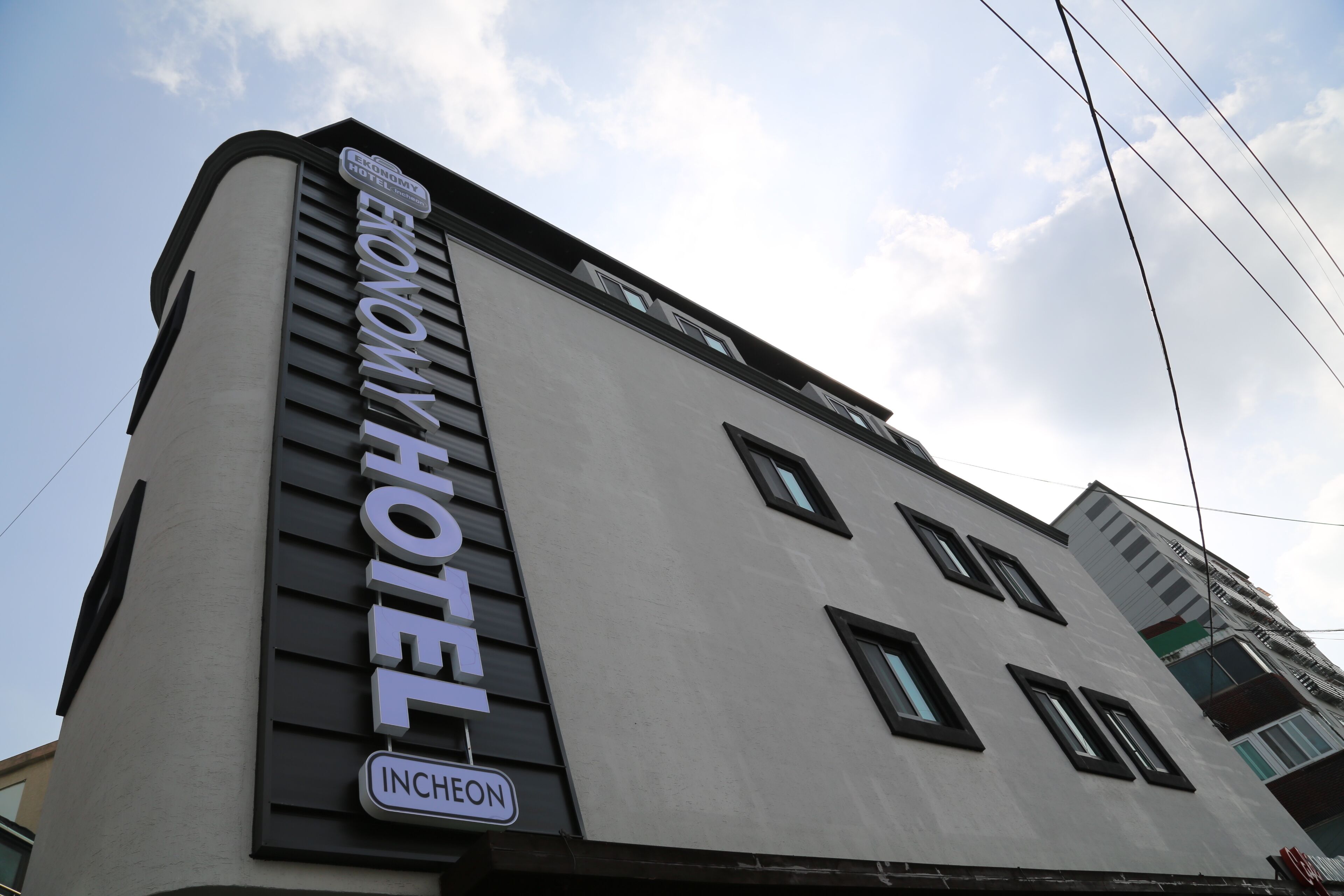 A hotel with a sign indicating it is the 'Economy Hotel' in Inchon.