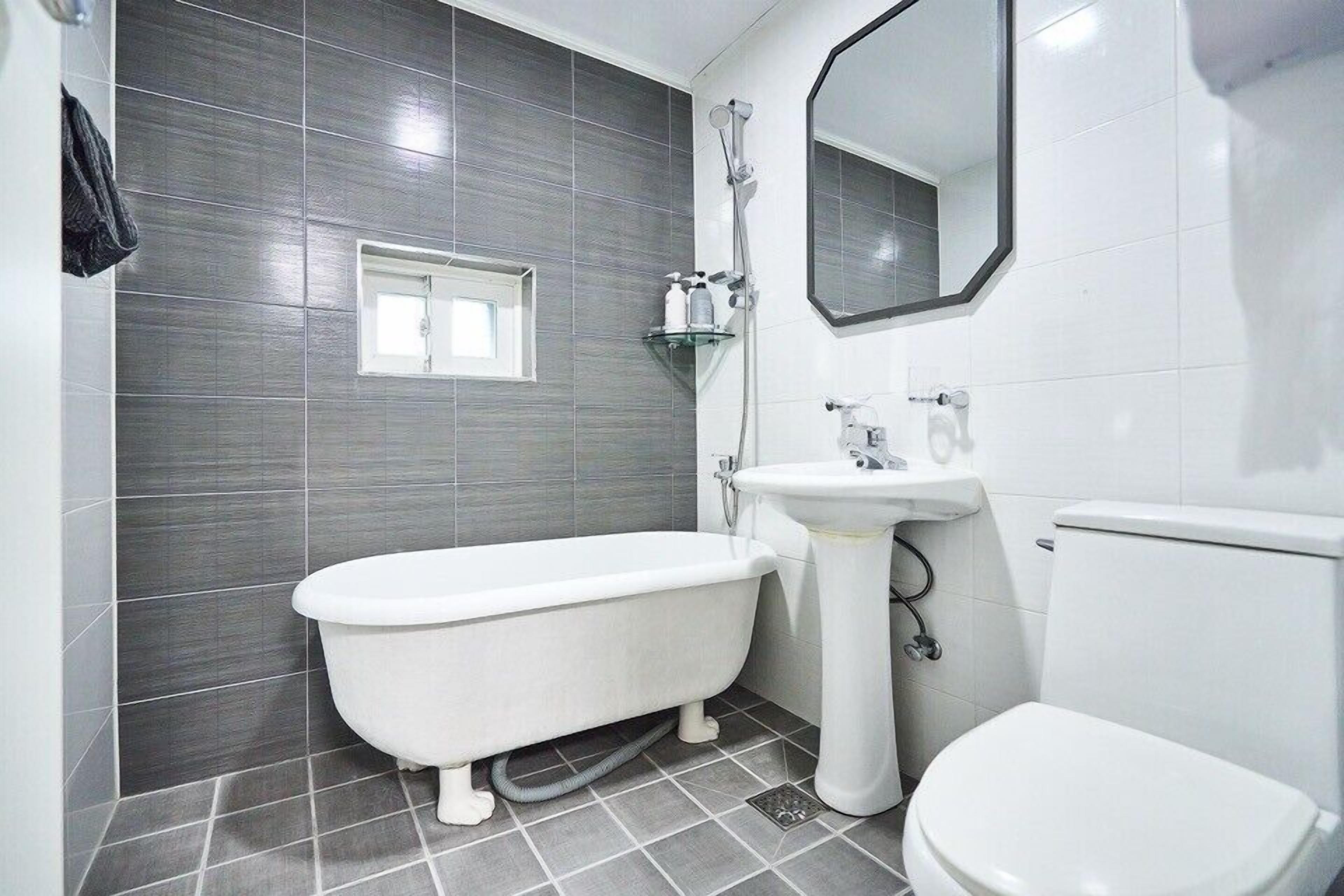 A bathroom with a bathtub, a sink, and a toilet.