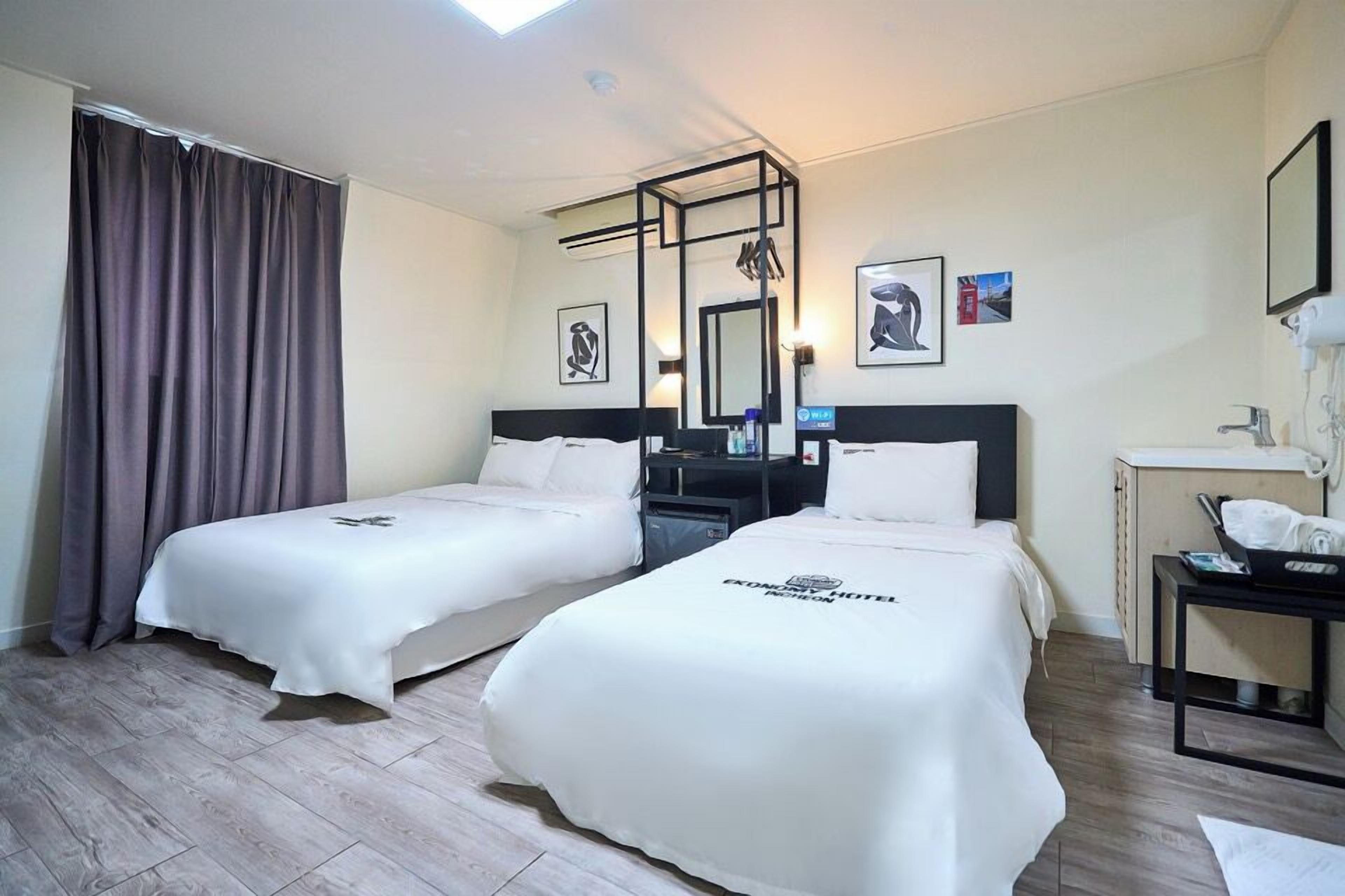 Habitación empresarial con 2 camas individuales | Ropa de cama de alta calidad, escritorio y cortinas blackout 