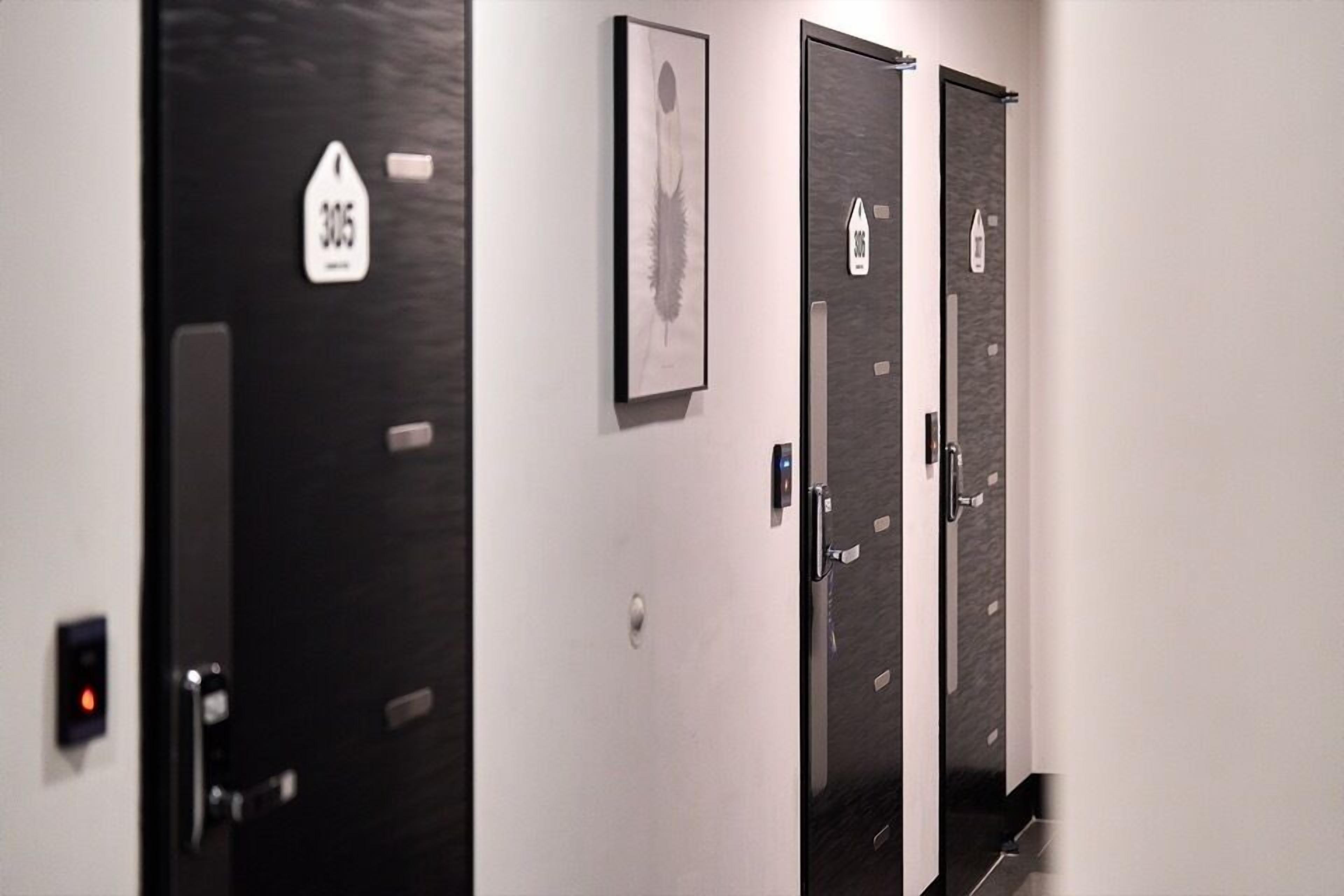 A hallway with three doors, each marked with a number and a directional arrow.