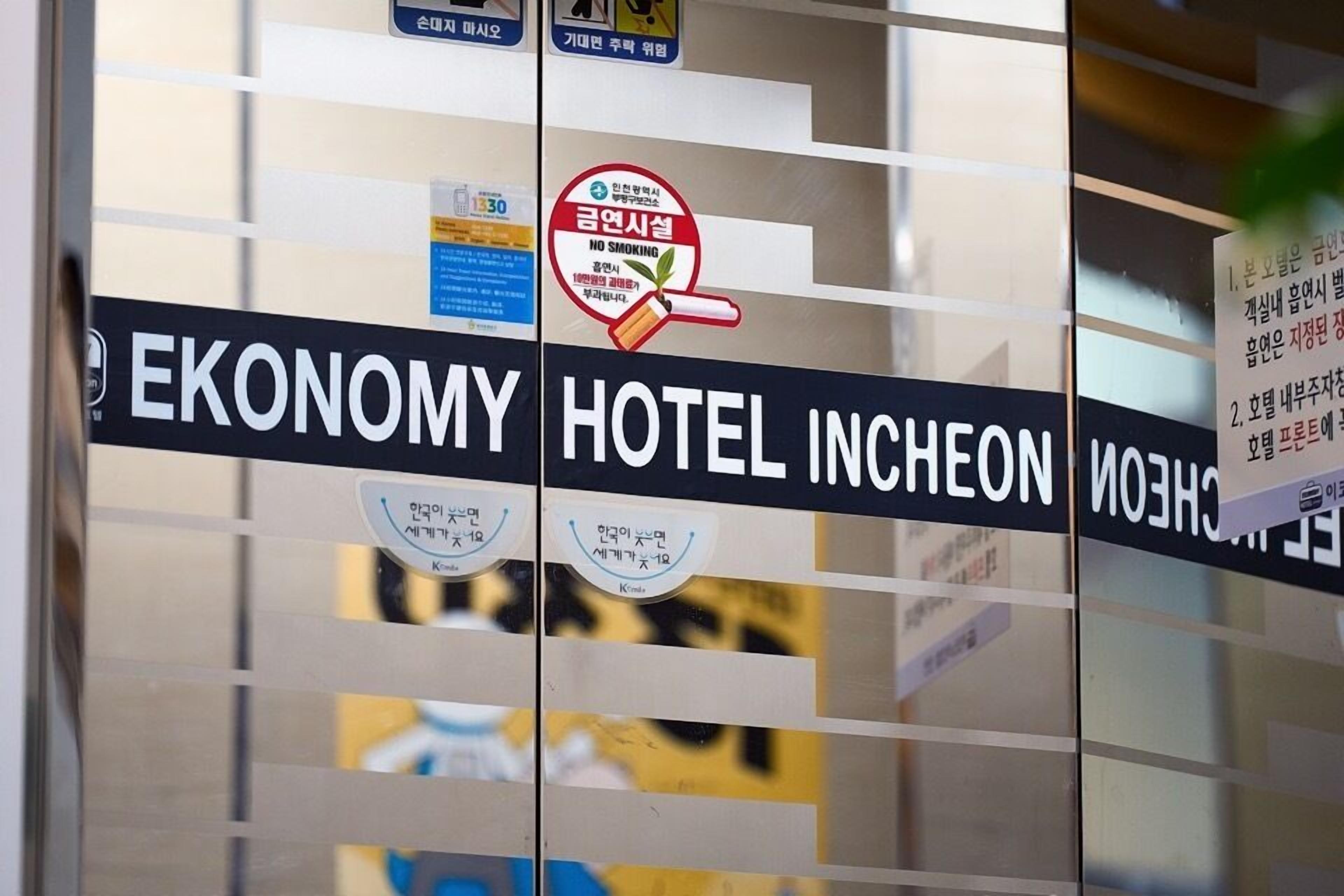 A hotel sign with 'ECONOMY HOTEL INCHEON' and a 'NO SMOKING' sign.