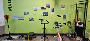 Un gimnasio con equipo de ejercicio, una bicicleta estática y una guitarra.