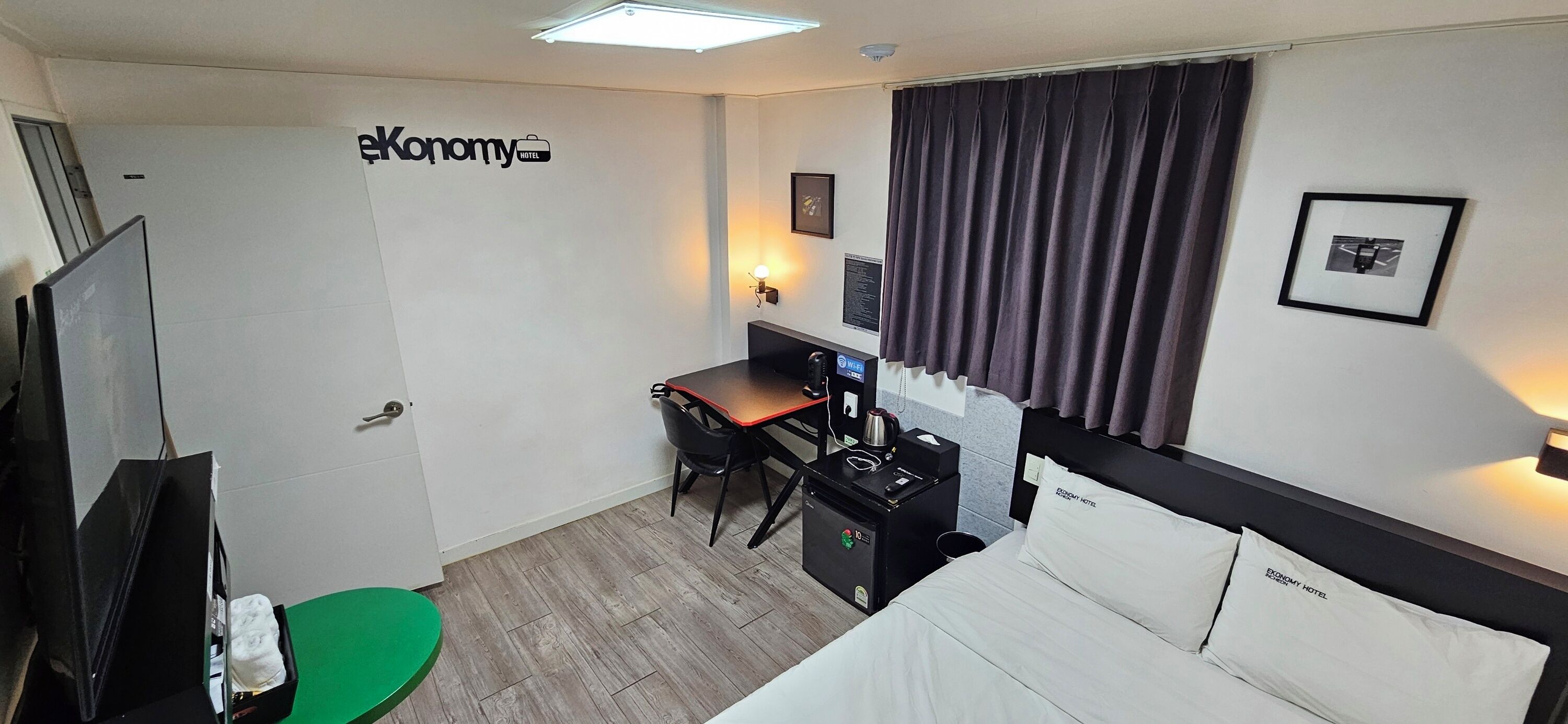 Una camera d'albergo con un letto, una scrivania e un angolo cottura.