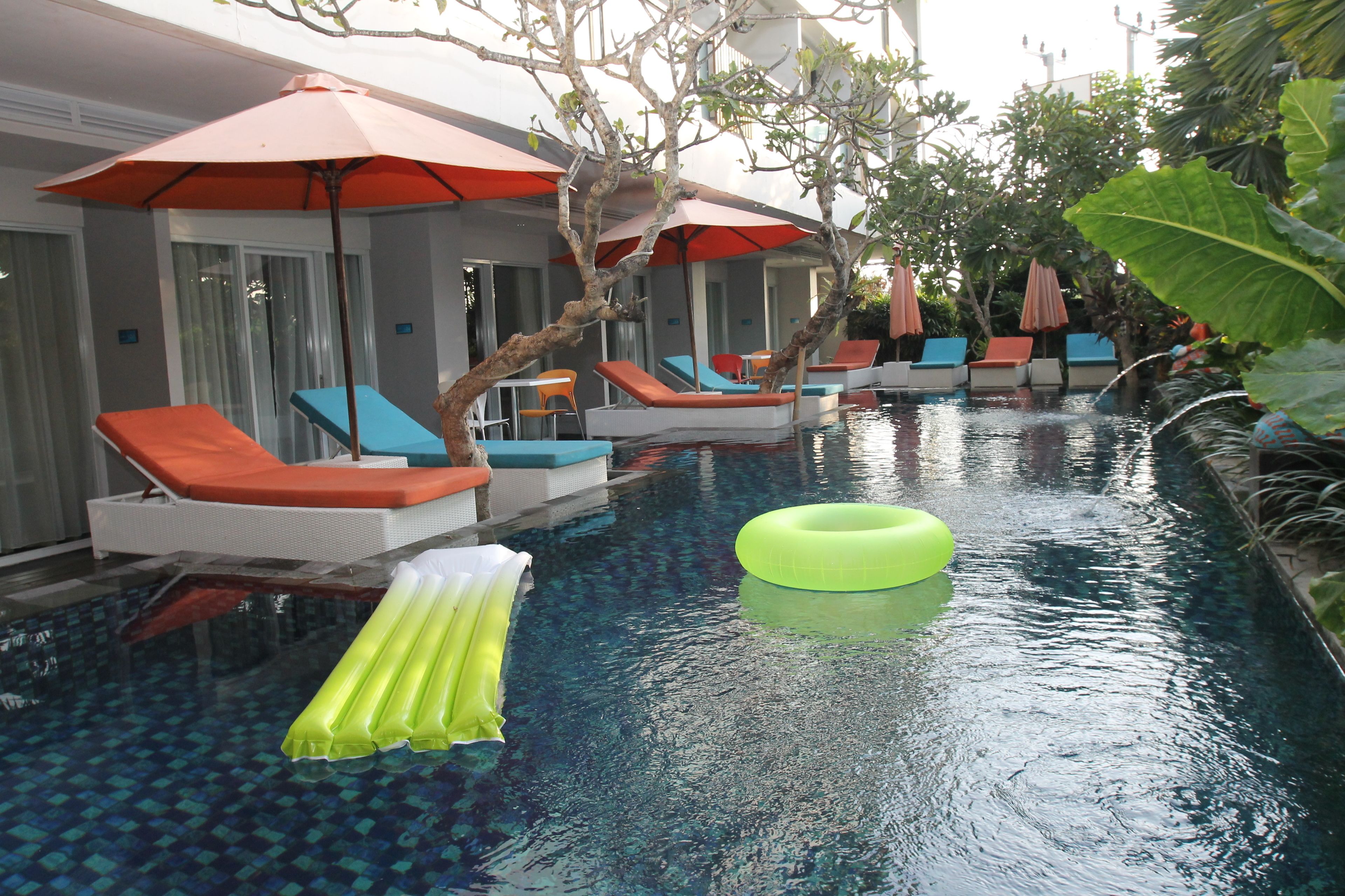 An indoor swimming pool with lounge chairs and umbrellas.