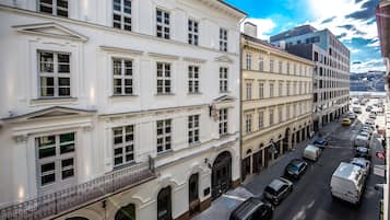 Um edifício de vários andares com arquitetura clássica, apresentando janelas simétricas e molduras decorativas.