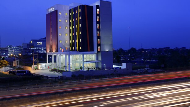 A modern hotel with a prominent 'XXI' sign, multiple floors, and a well-lit facade. - Amaris Hotel Bekasi Barat (Bekasi)