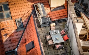 An outdoor terrace with a table and chairs, a small staircase, and a view of the adjacent building. - 4 Arts Apartments by Adrez Living (Prague)