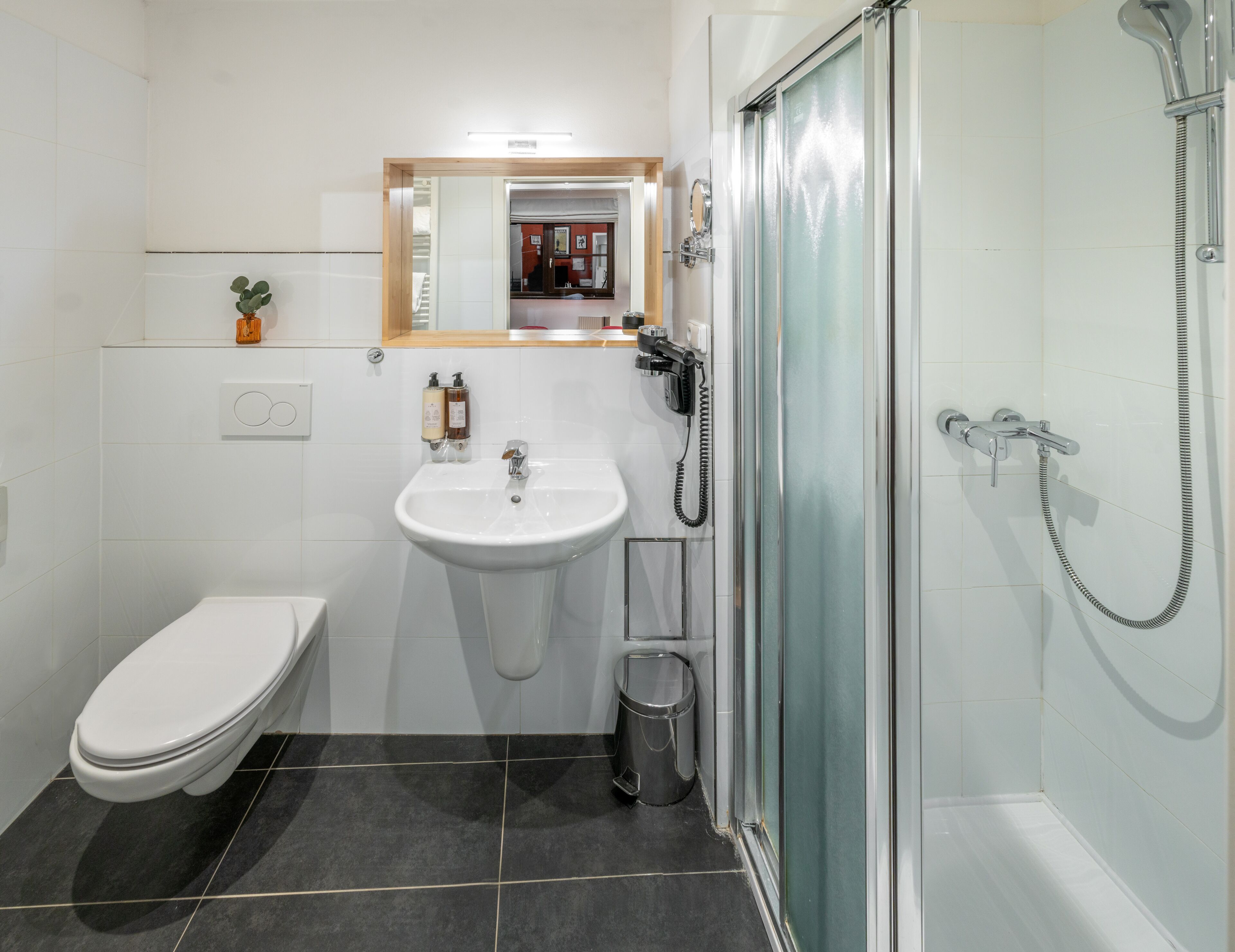 A modern bathroom with a toilet, sink, and shower.