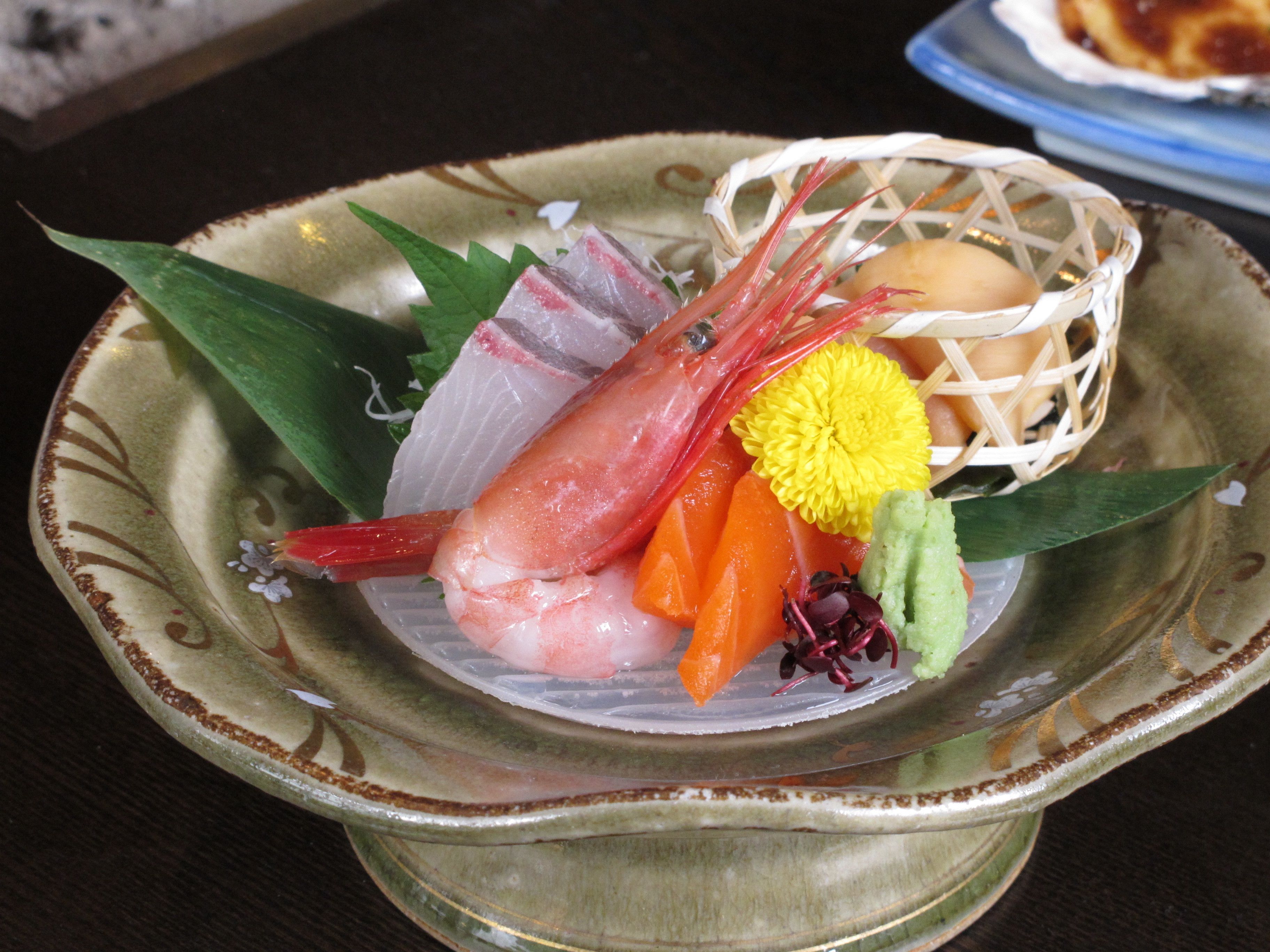 Ein Teller mit Sushi, Gemüse und einem kleinen Korb.