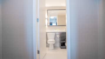 Une salle de bain avec des toilettes, un lavabo et un miroir.
