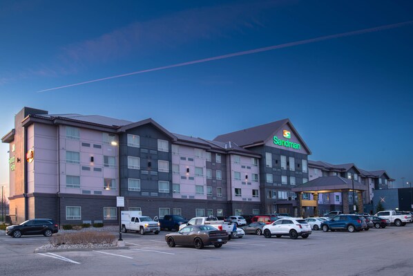 A hotel with multiple floors, a parking lot, and a visible sign for the Sandman hotel. - Sandman Hotel Oakville (Oakville)