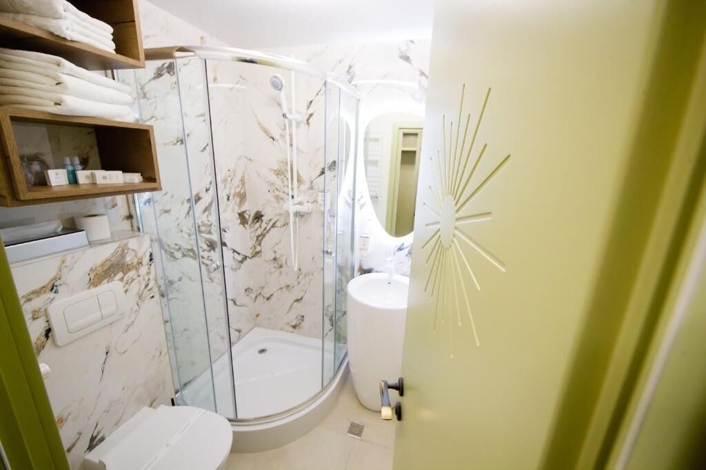Un baño con ducha de vidrio, inodoro y lavabo.