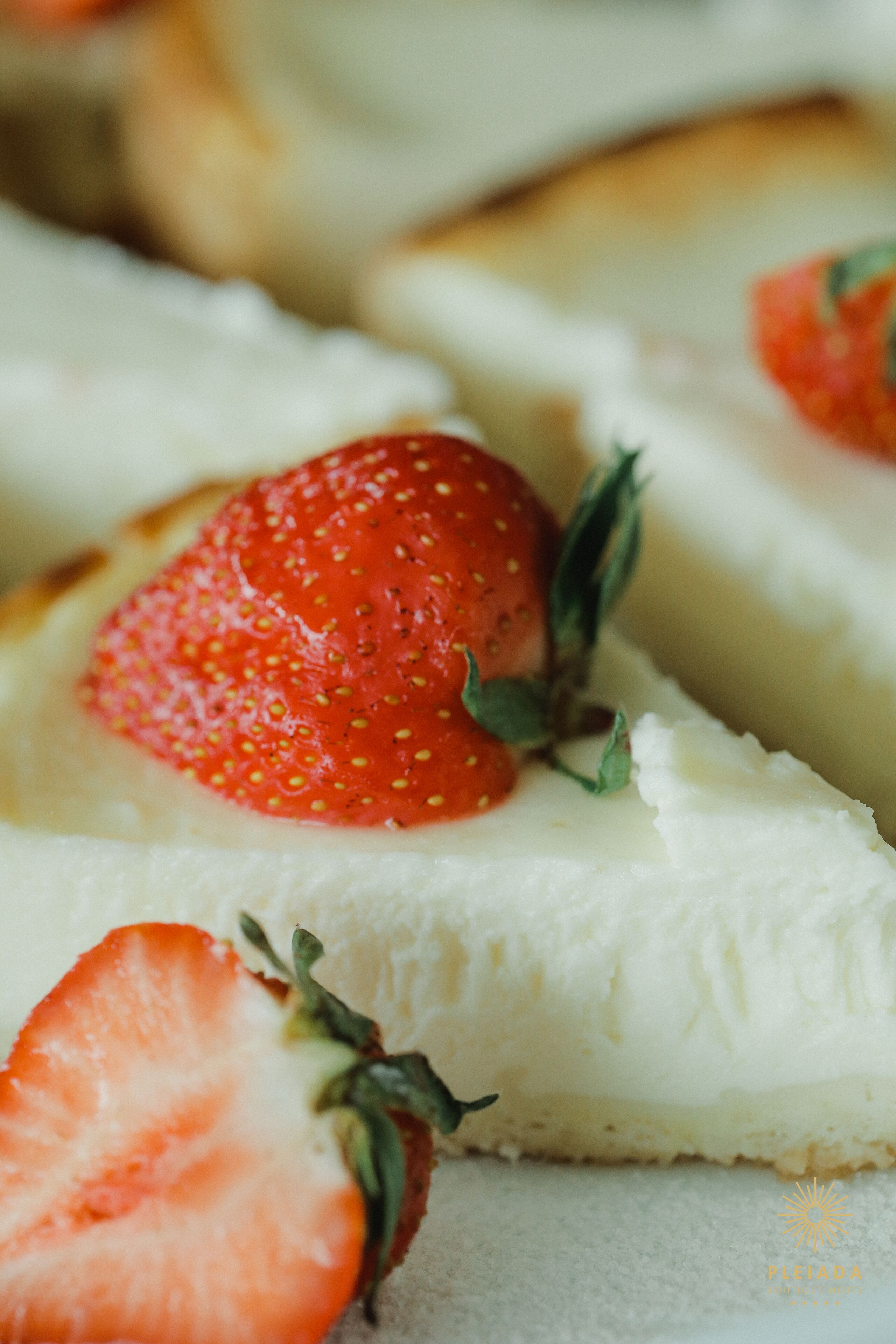 A slice of cheesecake topped with a strawberry and a sprig of thyme.