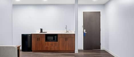 Una cocina moderna con armarios de madera, un microondas y un lavamanos.