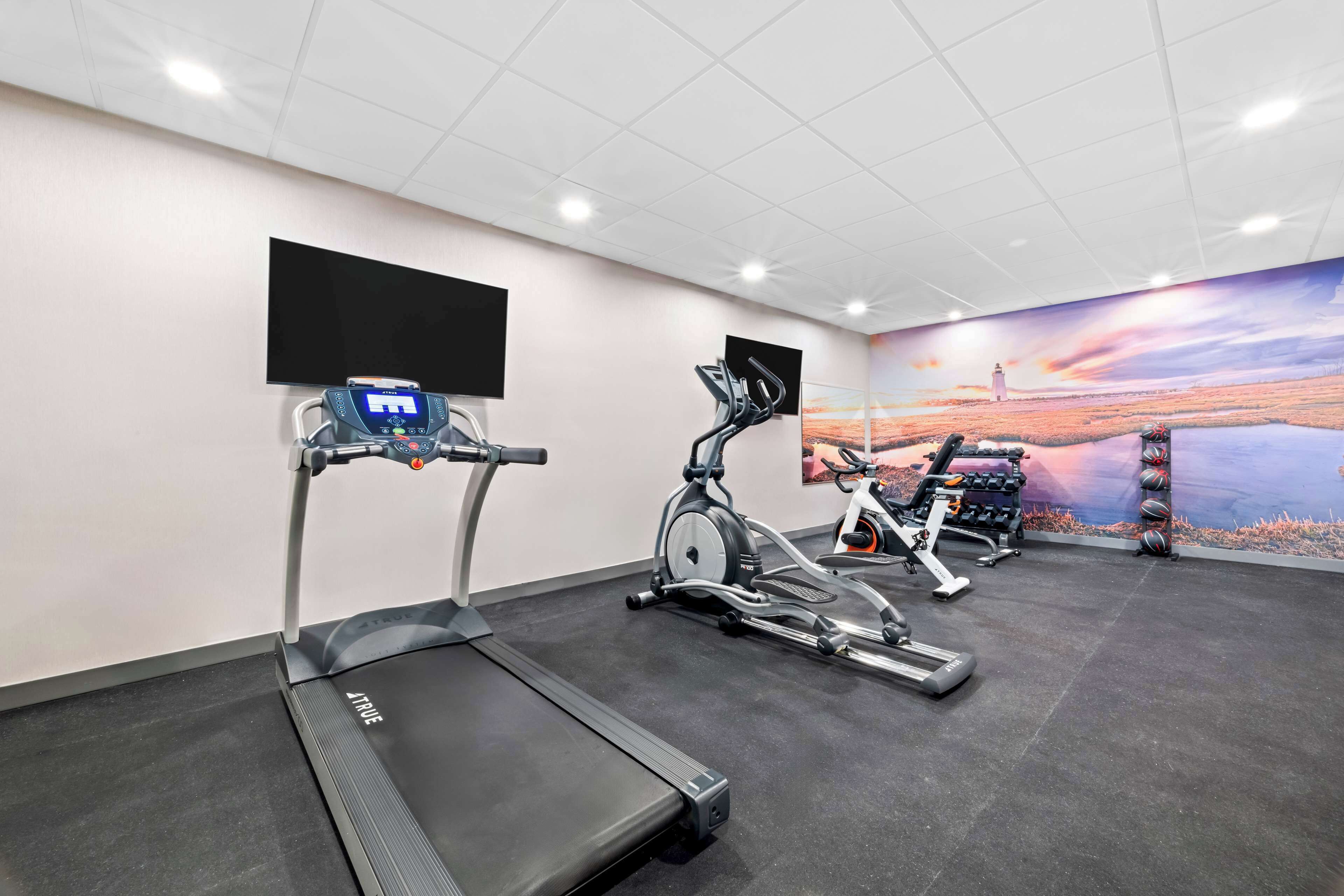 A gym with treadmills, an elliptical, and a stationary bike.