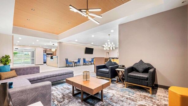 A modern lobby with a wooden ceiling, a large sofa, a coffee table, and a seating area with armchairs. - Best Western Niantic - New London/Mystic Area (Niantic)