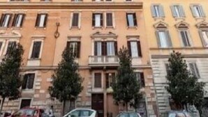 Una hilera de edificios de varios pisos con un estilo arquitectónico uniforme, que presenta balcones y ventanas.