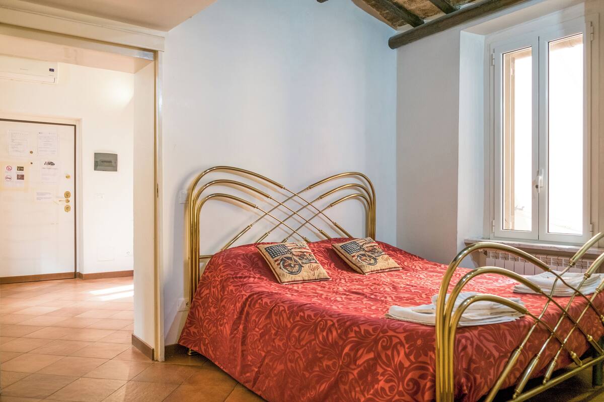 Un dormitorio con cama, ventana y puerta.