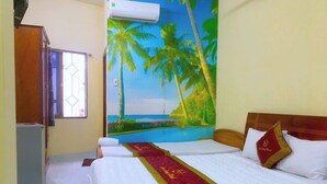 A hotel room with two beds, a painting of a beach scene, a refrigerator, and a window with curtains. - Son Tung Hotel (Ho Chi Minh City)